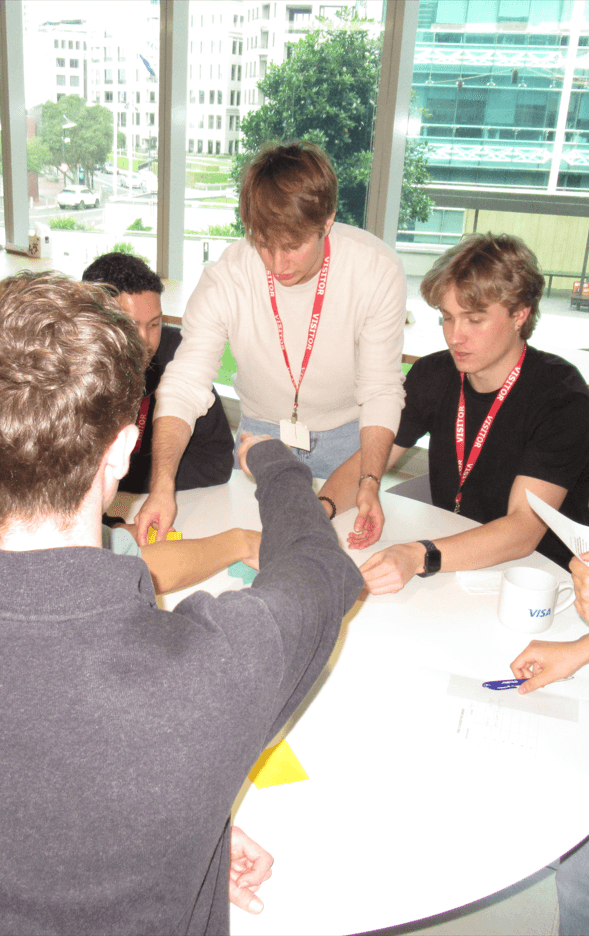 Working through a problem with other students around a table on an industry visit